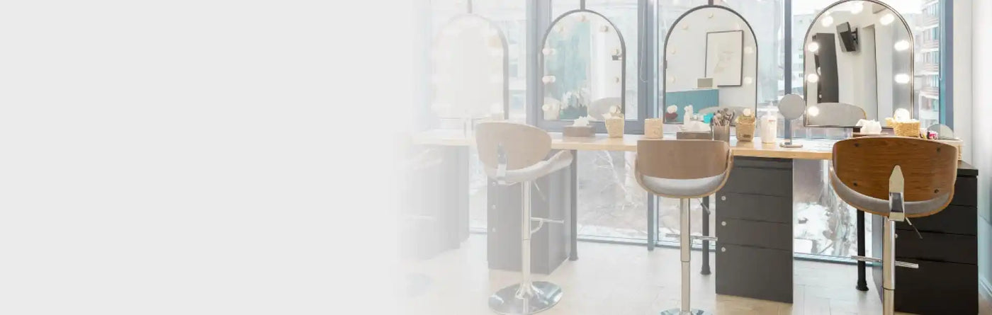 Modern szalon munkaállomás bézs bőr hajvágó székekkel és ívelt tükörrel.
