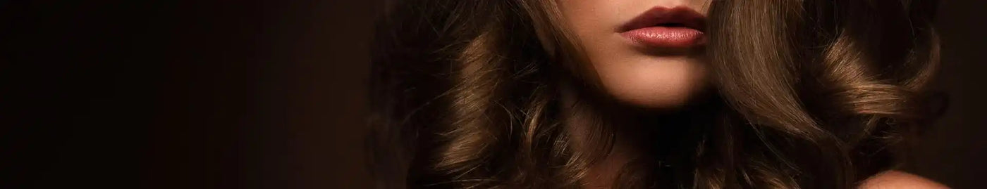 Sötét göndör haj és piros rúzs egy drámai szépségportréban.